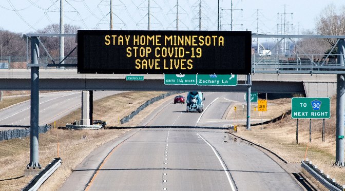 Electronic highway sign with COVID-19 message: Stay Home Minnesota. Stop COVID-19. Save Lives.