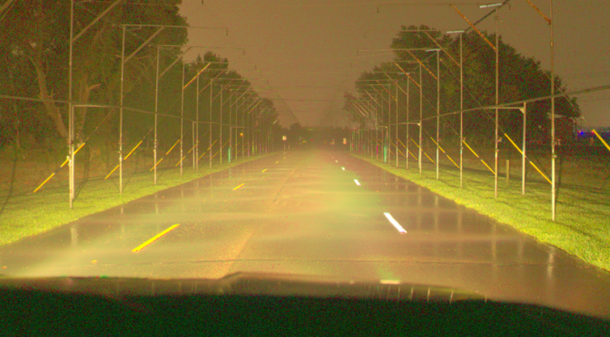 Wet driving conditions with reflective pavement markings on road