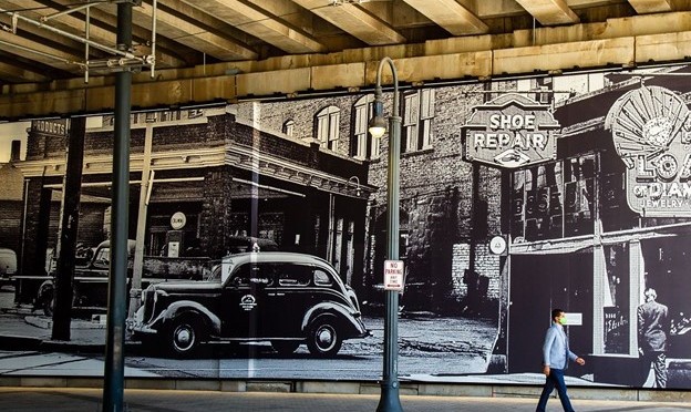 A large mural on the wall of a highway underpass shows storefronts along Auburn Avenue in Atlanta.